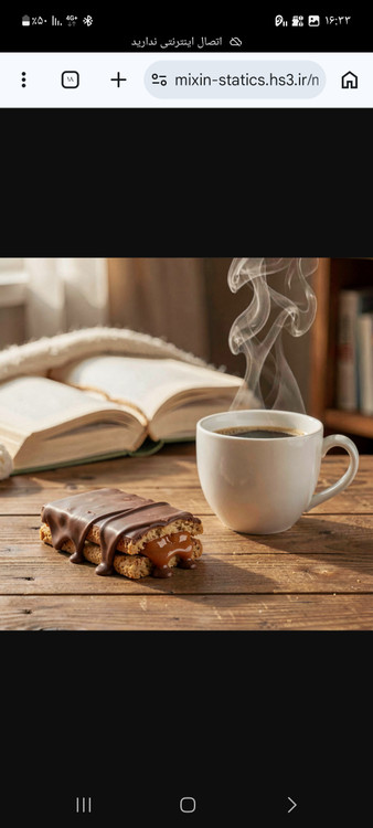 شکلات آلبنی در کنار فنجان قهوه و کتاب در فضای آرامبخش